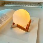 Luminária lua LED acesa decorando mesa branca de quarto