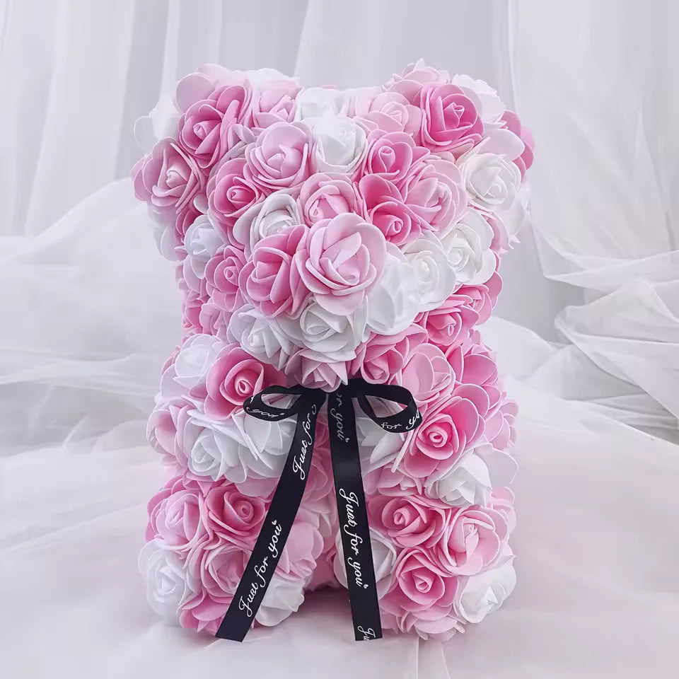 Ursinho de rosas rosa claro com branco envolto em panos brancos